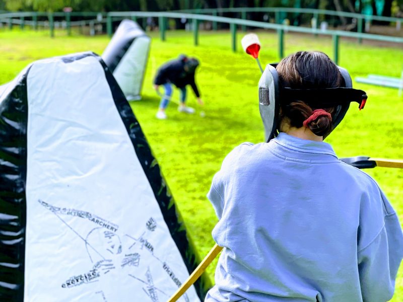 Girls playing archery tag, a game where you shoot foam arrows at each other