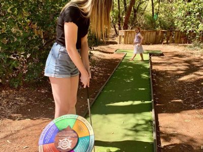 woman playing golf with young girl
