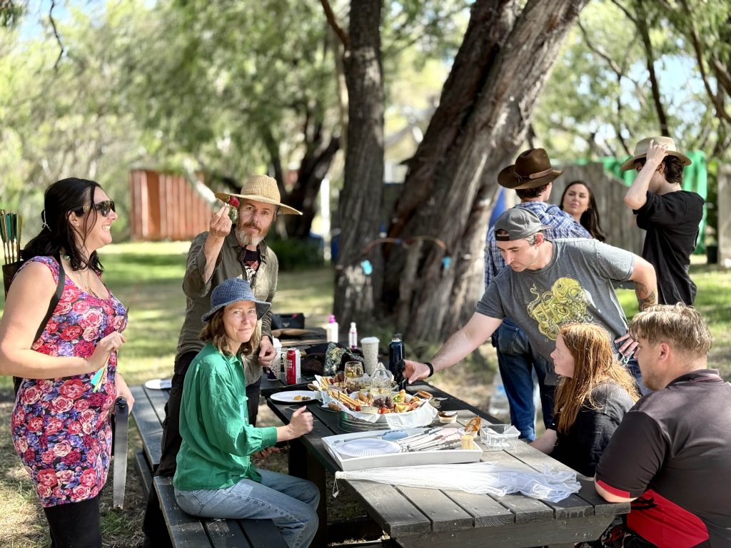 People injoying a picnic at the tables at Primal Archery